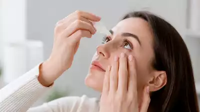 Lifestyle image depicting a person using eye drops