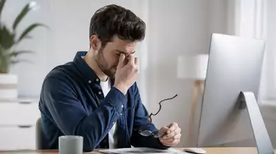 User working on a computer with eye strain